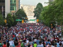 A crowd gathers on a busy Canadian street