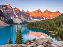 The sunrise over Moraine Lake and the mountains hugging the shore in Banff National Park (Alberta, Canada).